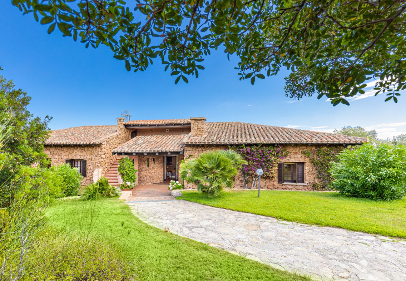 Villa Halliv - Garten mit grünem Rasen und Entspannungsbereich im Klodge Ferienhaus auf Sardinien